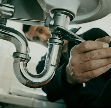 Licensed plumber performing preventive sink maintenance at a managed rental property in the Greater Toronto Area.